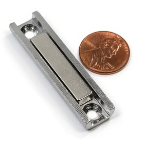65 lb pull neodymium channel magnet in a steel channel, 3.25 x 1/2 x 1/4 inch, shown next to a penny for scale — the wall side of a magnetic tablet mount
